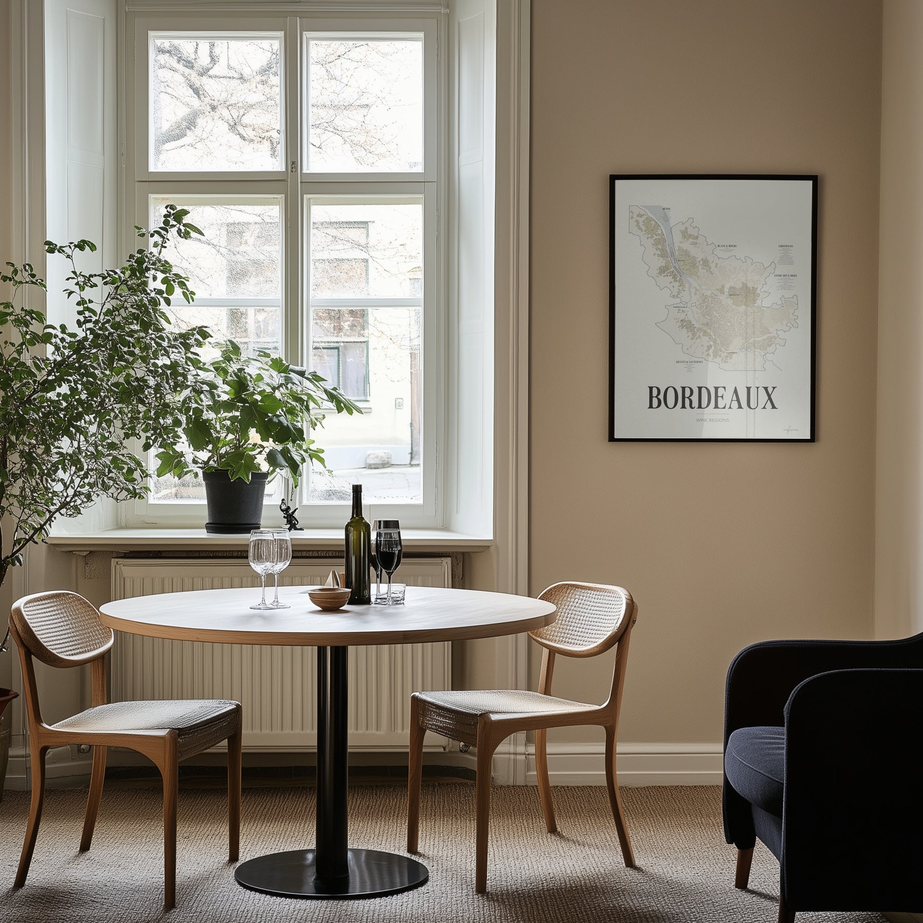 Bordeaux Wine Map poster by Corkframes framed on a wall beside a window, with a small dining table and wine glasses
