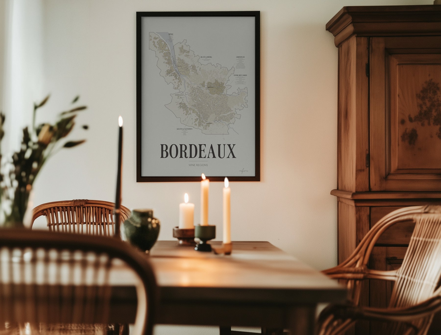 Bordeaux Wine Map poster by Corkframes in a black frame in a dining room with candles and an antique wooden cabinet