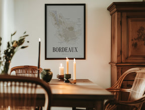 Bordeaux Wine Map poster by Corkframes in a black frame in a dining room with candles and an antique wooden cabinet