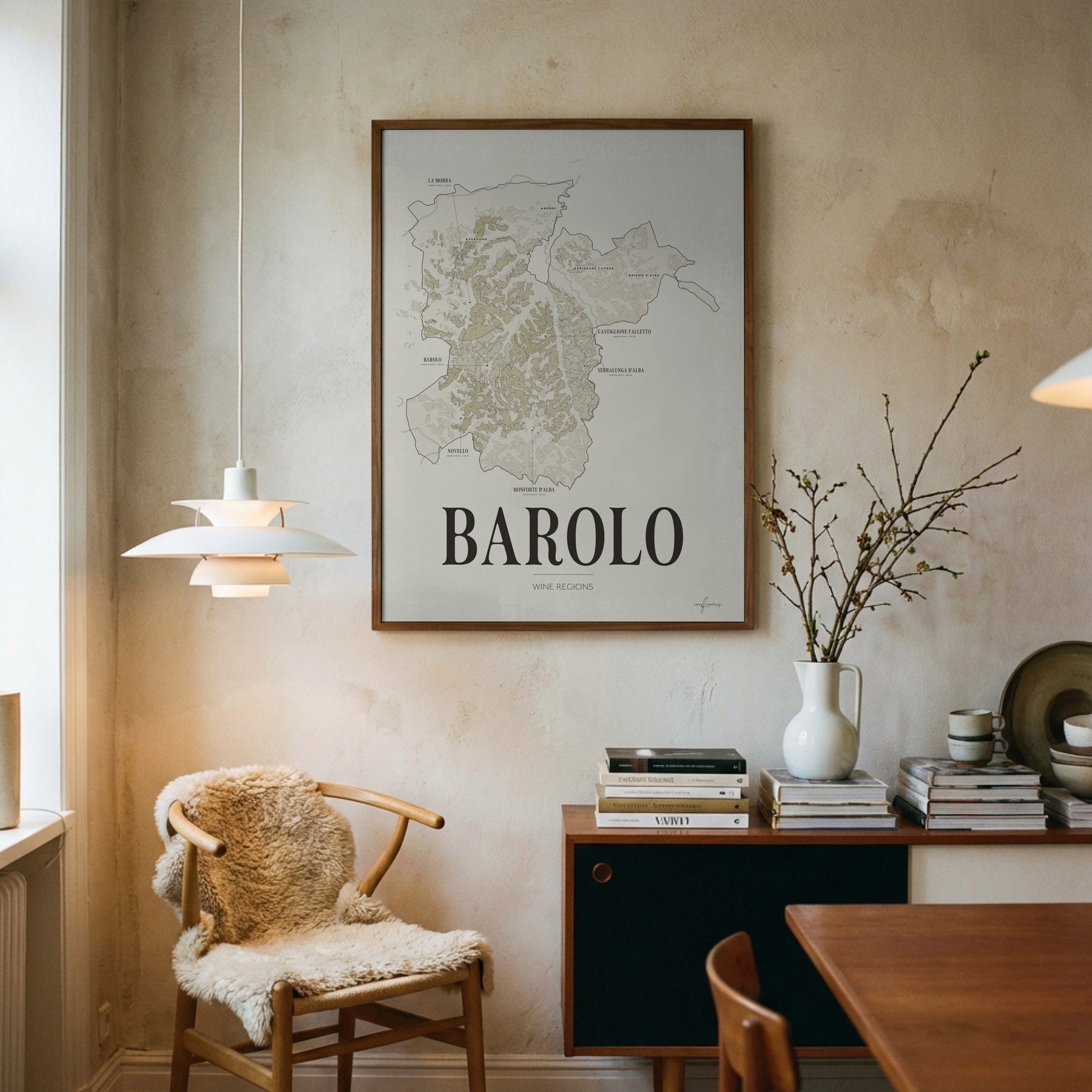 Barolo Wine Map poster by Corkframes framed on a plaster wall above a desk, with a sheepskin chair and a pendant lamp