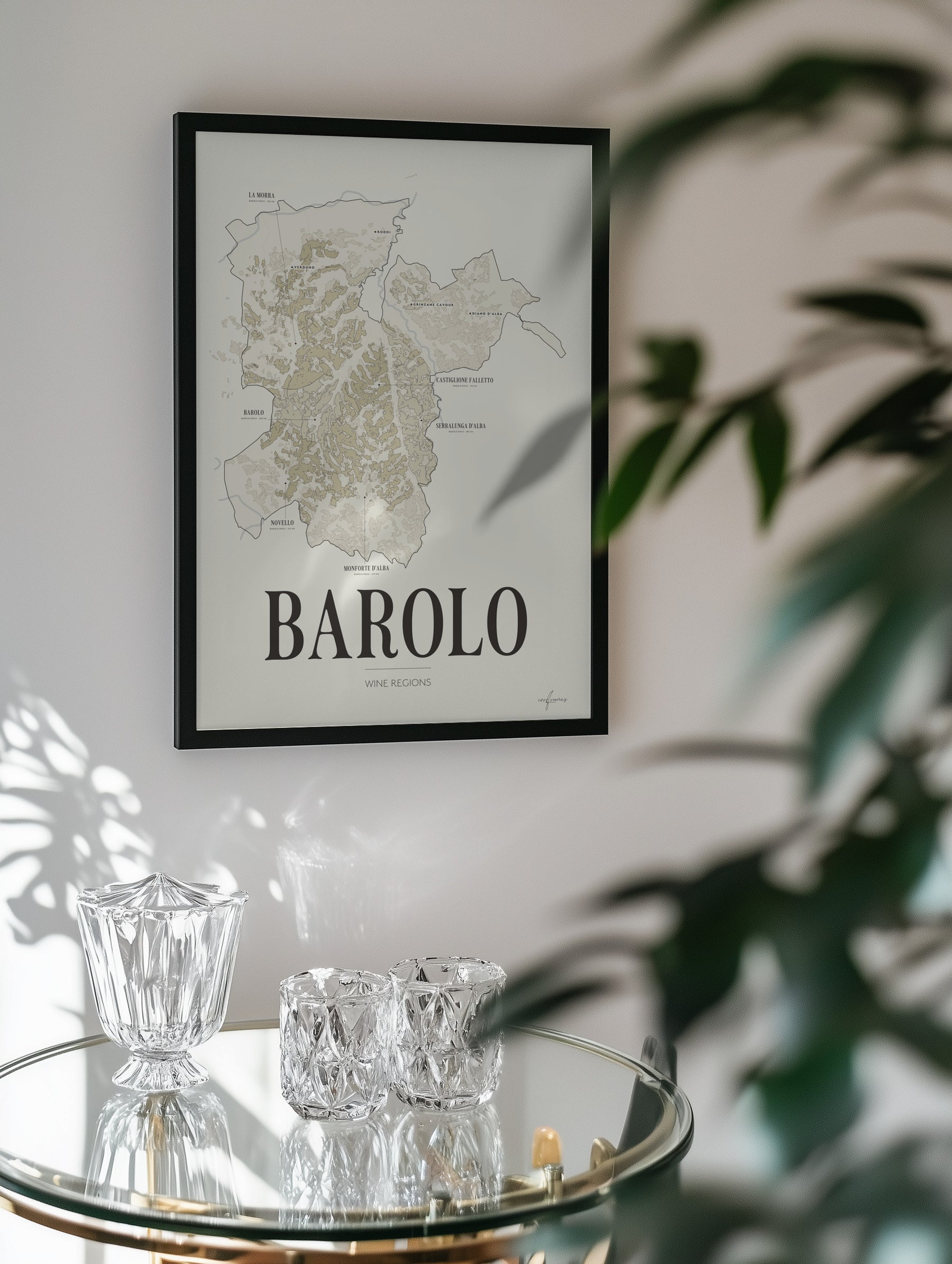 Barolo Wine Map poster by Corkframes framed on a wall behind a glass drinks trolley and a plant