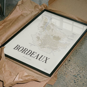 Bordeaux Wine Map poster by Corkframes in a dark frame, resting in tissue paper packaging