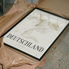 Deutschland Wine Map poster by Corkframes in a dark frame, resting in tissue paper packaging